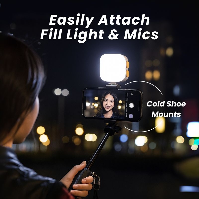 Person using a smartphone with a light attachment in a dark setting, highlighting cold shoe mounts.